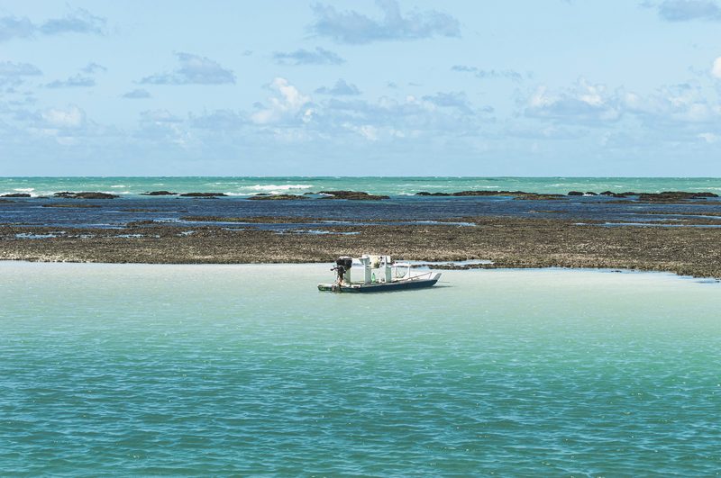 Piscina natural de Maragogi com barco e águas cristalinas